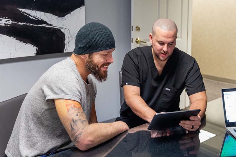 Justin Chamberland reviewing a client's scalp during a Scalpworx consultation
