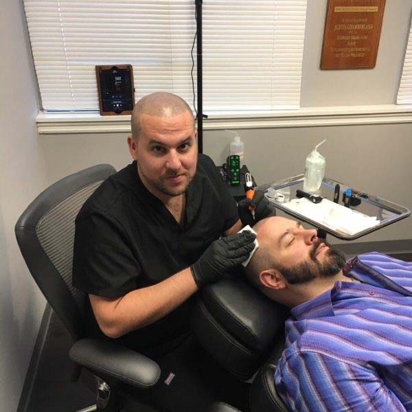 Pigment being applied to the scalp during an SMP session